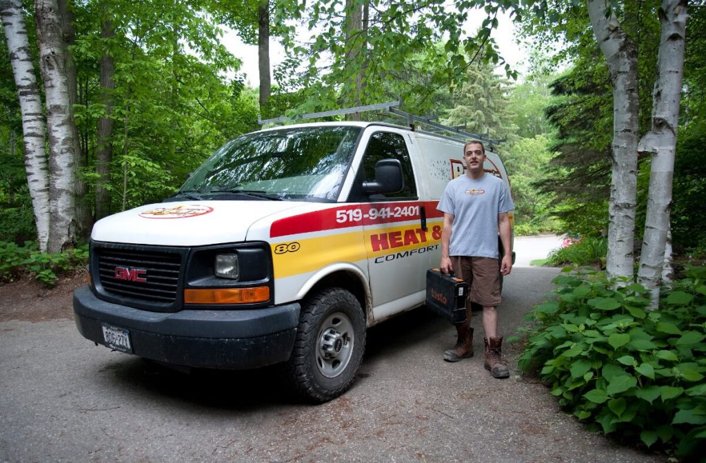 A photo of a Bryan's Fuel employee standing beside a Bryan's Fuel Van in a driveway.