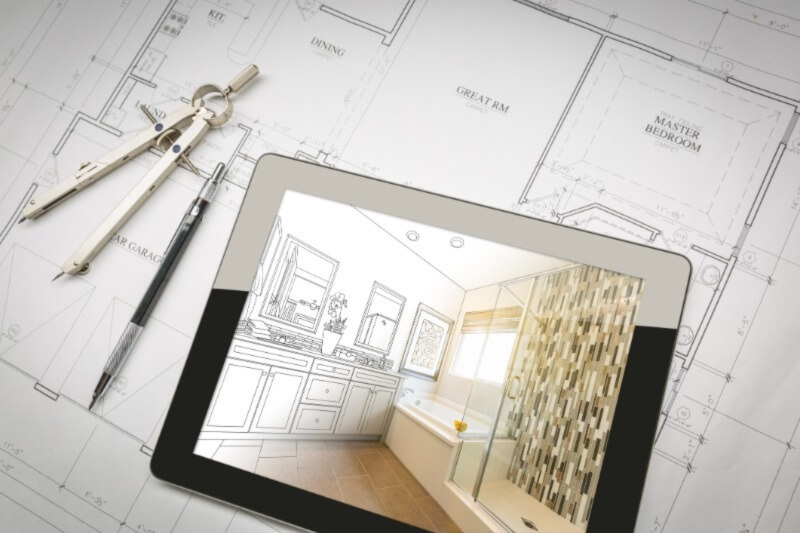 A photo of an iPad featuring a kitchen design sketch on the screen. It its on top of a drafted floor plan for a new custom home. 