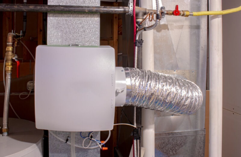 A photo of a whole house purifier installed in a home basement.