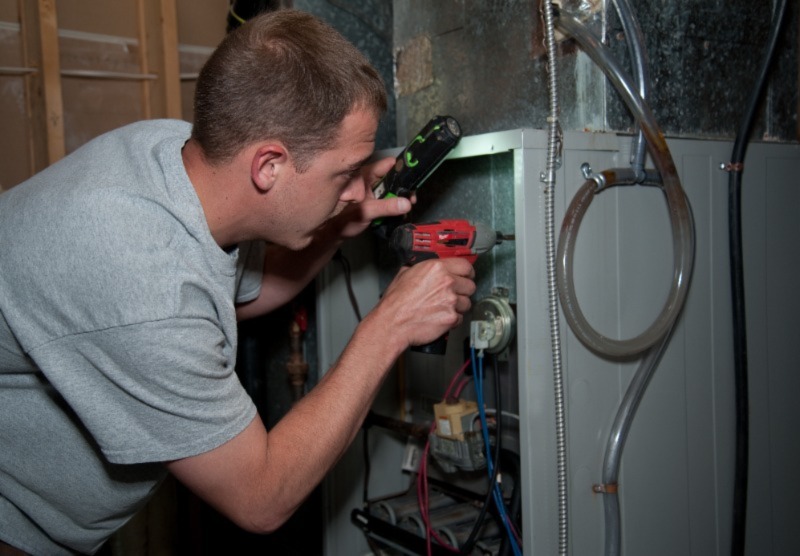 A Bryan's Fuel technician serving a furnace. 