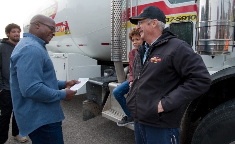 A Bryan's Fuel technician helping a family with fuel information. 
