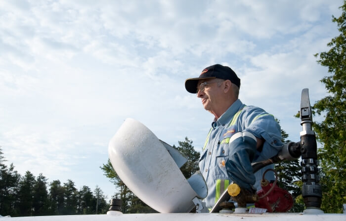 A photo of a Bryan's Fuel employee opening a propane tank to fill it.
