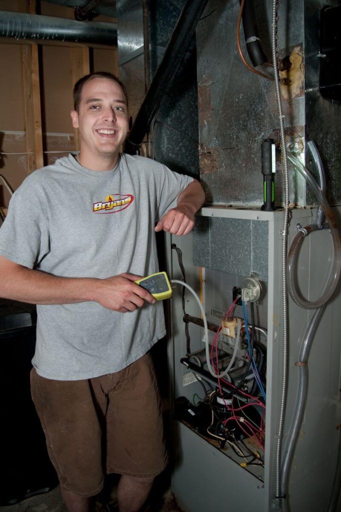 A photo of a Bryan's Fuel HVAC technician checking a furnace.  
