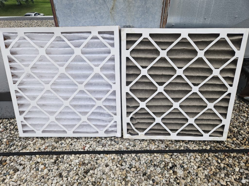 A clean furnace filter beside a dirty one.