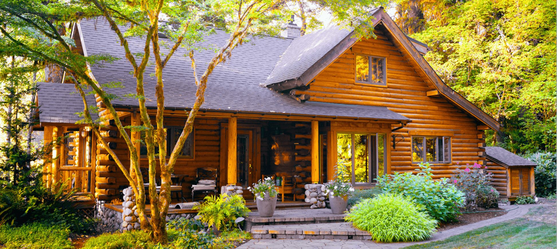 A cozy log cabin surrounded by lush greenery and vibrant flowers, nestled in a serene forest setting.