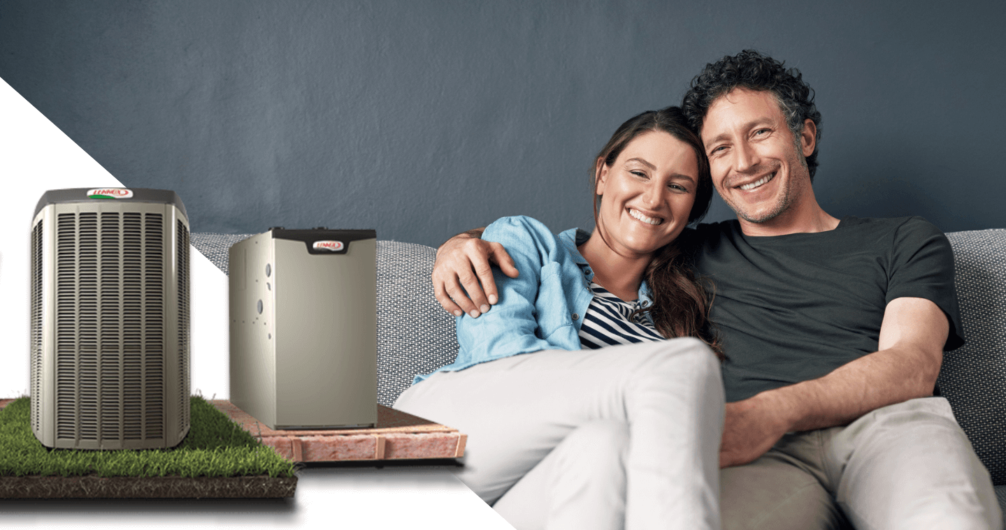 Two people smiling on a couch beside Lennox air conditioning units, suggesting comfort and efficient home cooling or heating system.