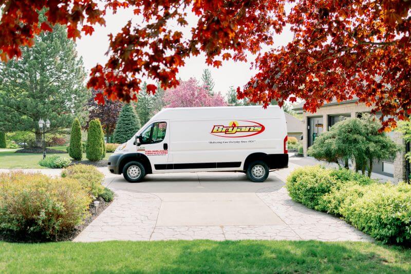A photo of a Bryan's Fuel service van in a driveway in fall.