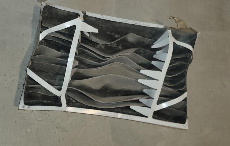 A phot oof a dirty furnace filter on the floor.
