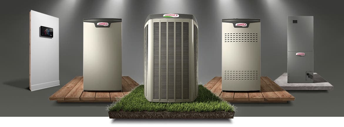Five air conditioning units displayed on platforms, with one on grass. A digital thermostat is mounted on a wall in the background.