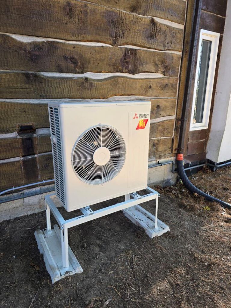 A Mits Heat Pump installed next to a house.