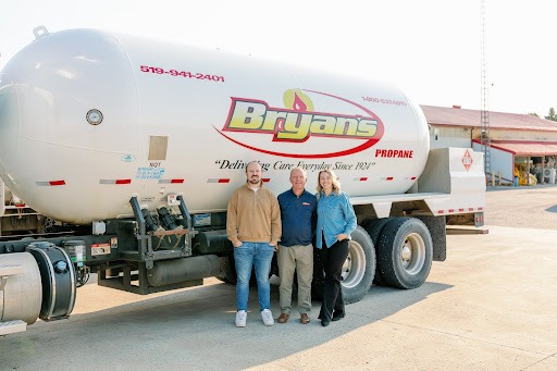 A photo of the Bryan family of Bryan's Fuel, standing in front of a propane truck.