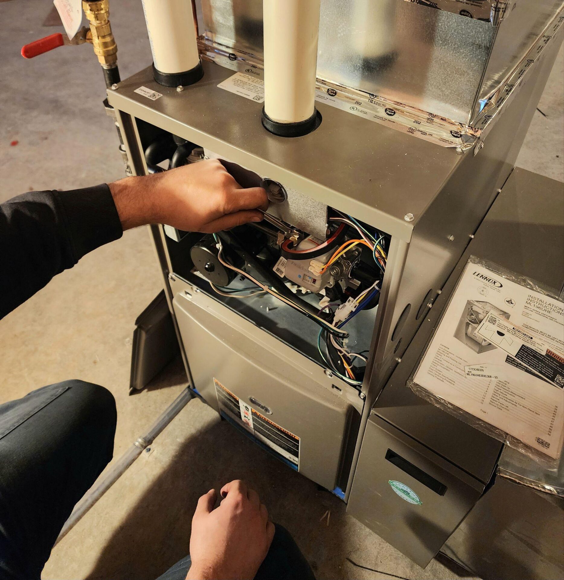 A technician looking at the inside of a furnace