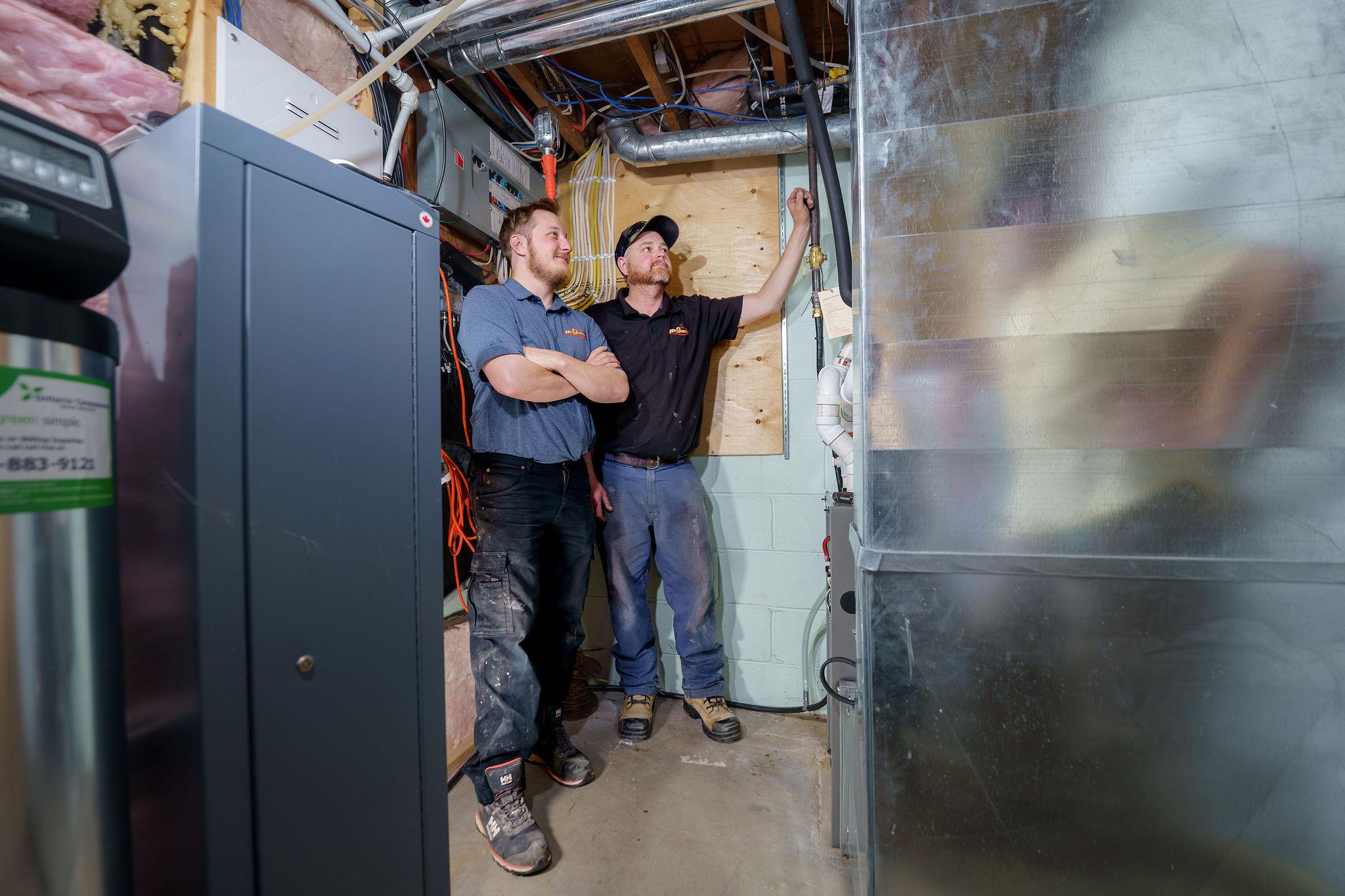 Two men inspecting a furnace
