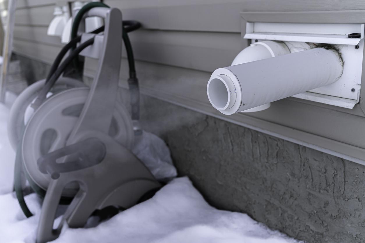 Vent outside home with snow on the ground.